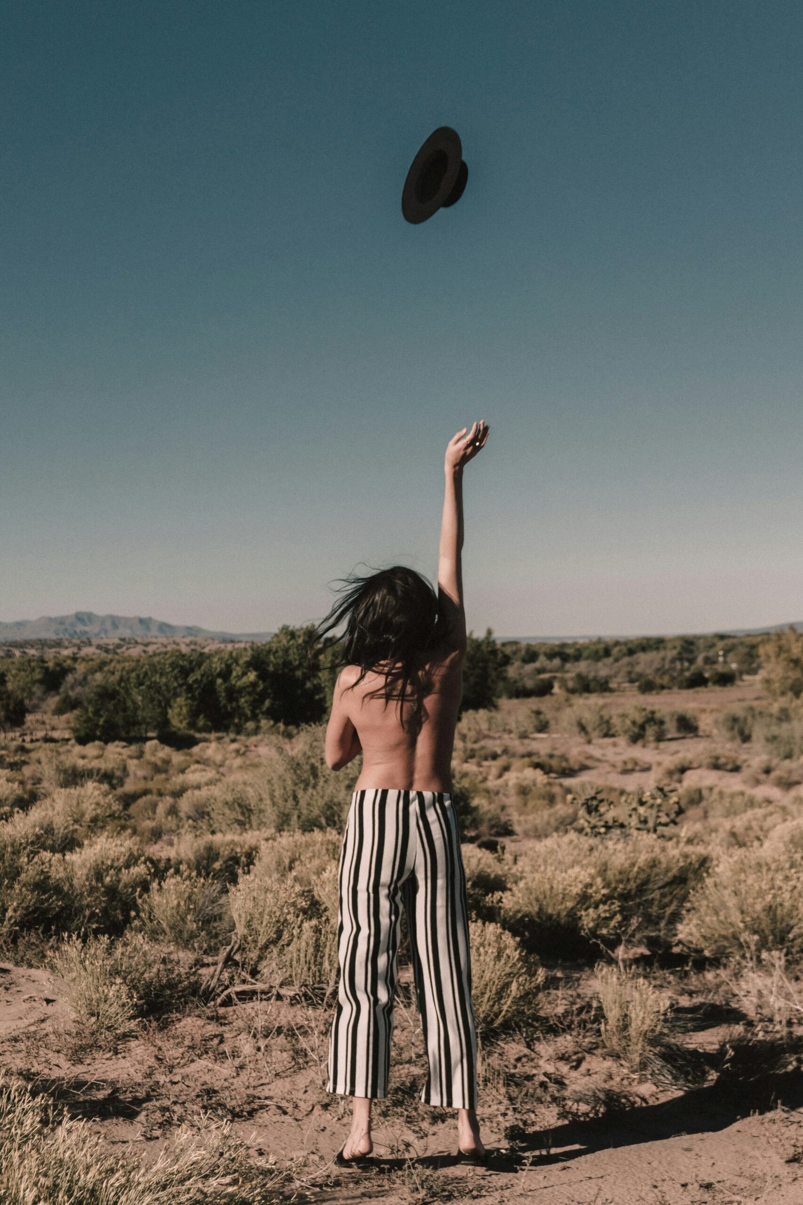topless person throwing black hat