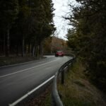 a red car driving down a curvy road